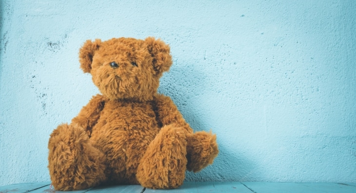 Brown teddy bear on blue background