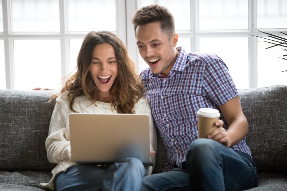 Happy couple using laptop