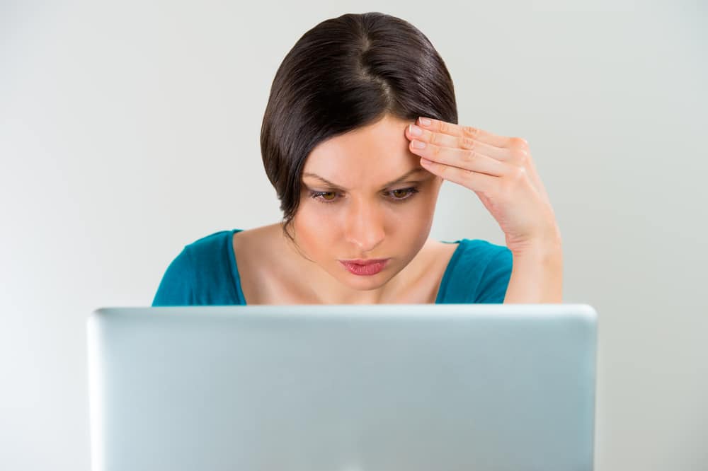 Unimpressed woman using laptop