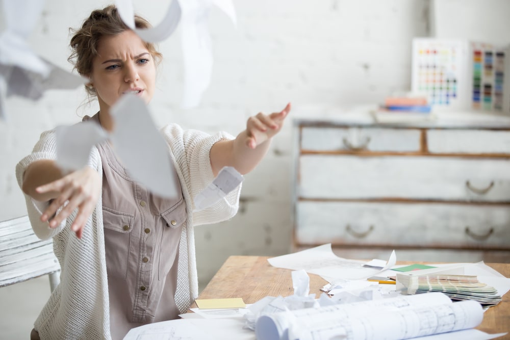 Young business woman throwing her work in the air