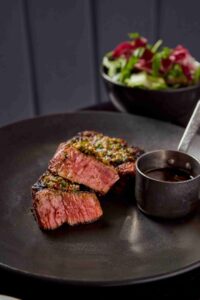 Plate of food in a restaurant, steak and salad