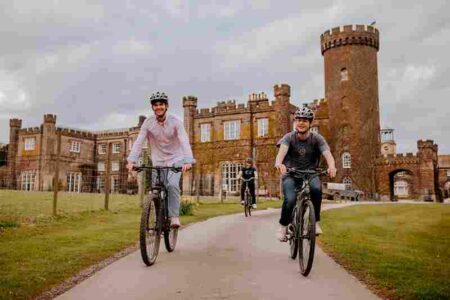 Family cycling outside castle